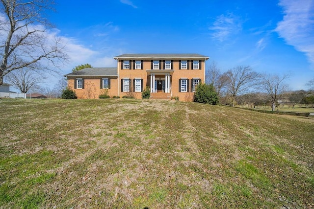 view of front of house featuring brick siding and a front lawn