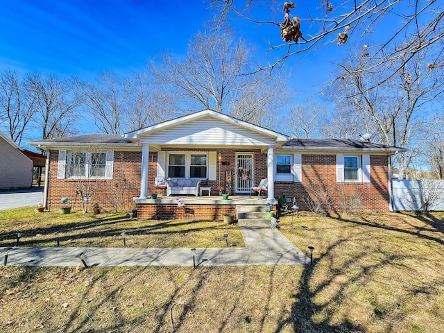 view of front of house featuring a porch, crawl space, a front yard, and brick siding