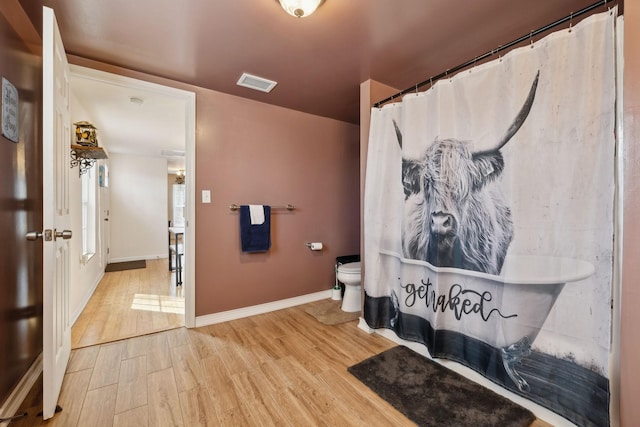 bathroom featuring baseboards, visible vents, toilet, wood finished floors, and curtained shower