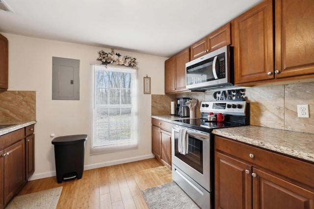 kitchen with stainless steel appliances, electric panel, plenty of natural light, and backsplash