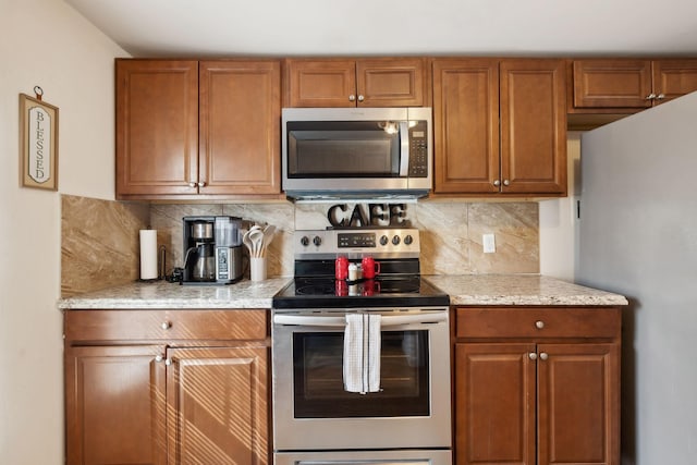 kitchen with appliances with stainless steel finishes, brown cabinetry, and tasteful backsplash