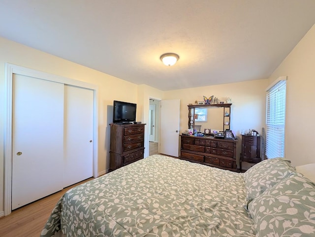 bedroom with light hardwood / wood-style floors and a closet