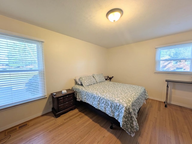 bedroom featuring hardwood / wood-style floors and multiple windows