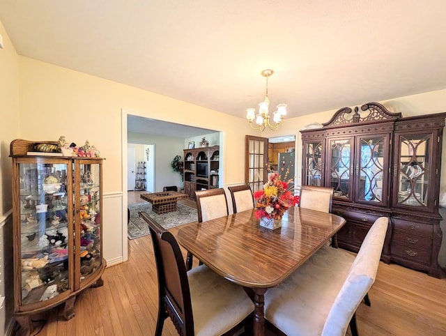 dining space featuring light hardwood / wood-style floors and a chandelier