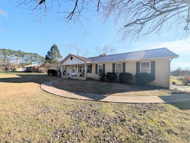 ranch-style house featuring a front yard, brick siding, and metal roof