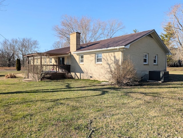 rear view of property featuring a yard, a deck, and central air condition unit