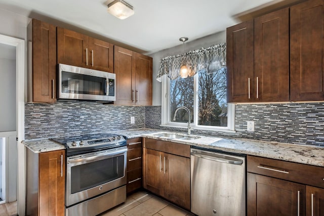 kitchen with light tile patterned flooring, stainless steel appliances, backsplash, and sink