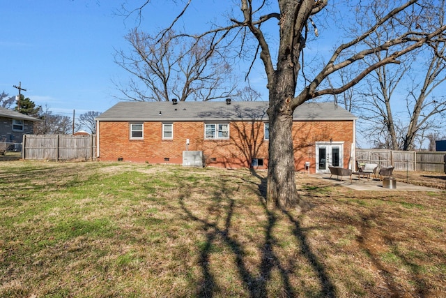 rear view of property featuring a yard, a patio, and french doors