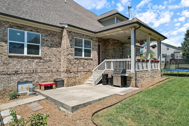 rear view of house with a patio area, a lawn, ceiling fan, and a trampoline