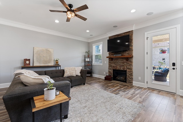 living room featuring a fireplace, ceiling fan, crown molding, and hardwood / wood-style floors