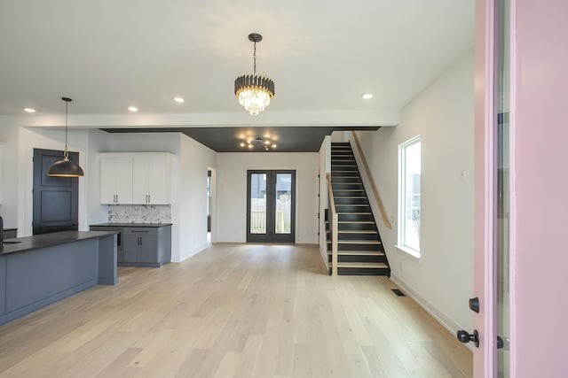 interior space featuring an inviting chandelier, light hardwood / wood-style floors, and french doors