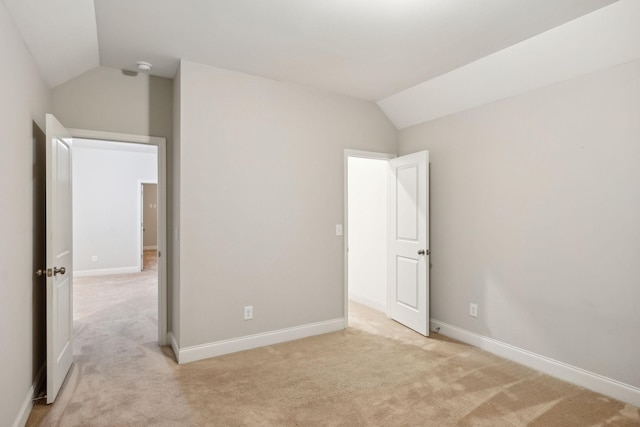 unfurnished bedroom with lofted ceiling and light colored carpet