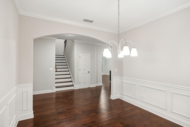 empty room with crown molding, dark hardwood / wood-style flooring, and a notable chandelier