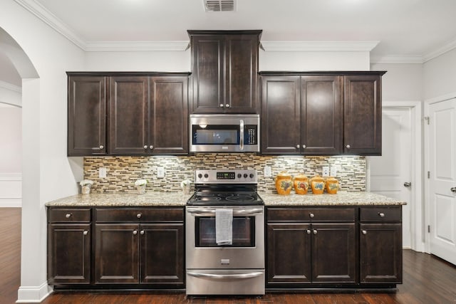 kitchen featuring appliances with stainless steel finishes, dark brown cabinetry, dark wood-type flooring, and decorative backsplash