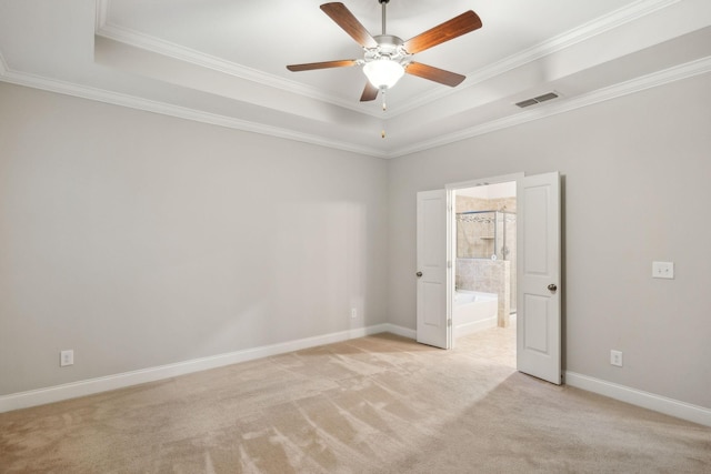 unfurnished room with a tray ceiling, light carpet, and crown molding