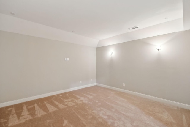 carpeted empty room with vaulted ceiling