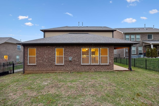 rear view of house with a patio and a lawn