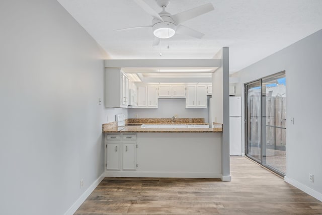 214 Cedarwood Ln Unit 214, Madison, TN 37115 - kitchen featuring freestanding refrigerator, white cabinets, wood finished floors, range, and light stone counters