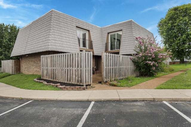 214 Cedarwood Ln Unit 214, Madison, TN 37115 - view of home's exterior featuring uncovered parking, brick siding, and mansard roof