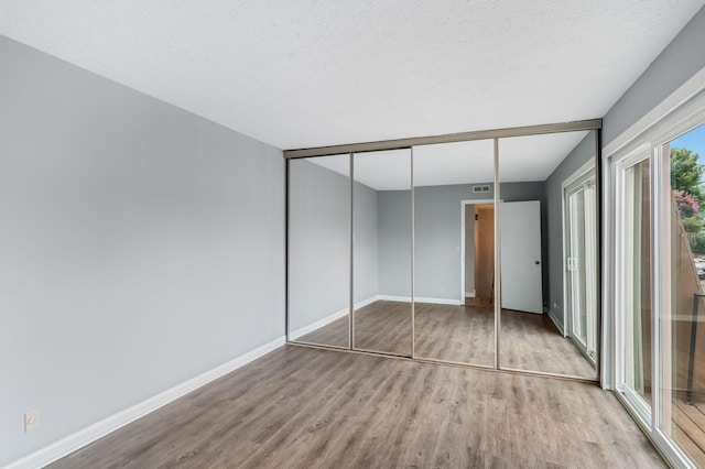 214 Cedarwood Ln Unit 214, Madison, TN 37115 - unfurnished bedroom featuring wood finished floors, a closet, and a textured ceiling