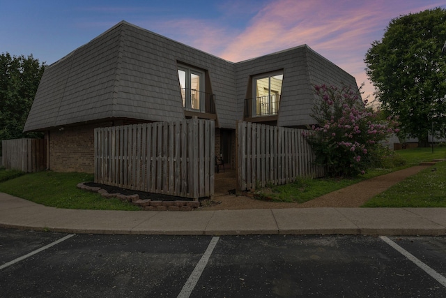 214 Cedarwood Ln Unit 214, Madison, TN 37115 - view of home's exterior with mansard roof, uncovered parking, brick siding, and a balcony