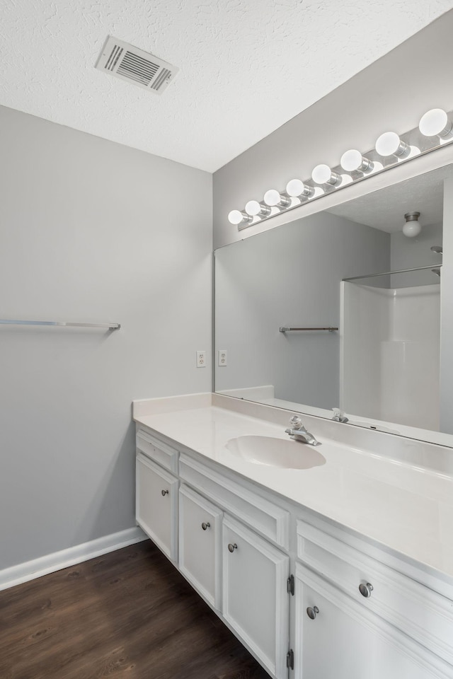 214 Cedarwood Ln Unit 214, Madison, TN 37115 - bathroom with vanity, wood finished floors, a textured ceiling, and a shower