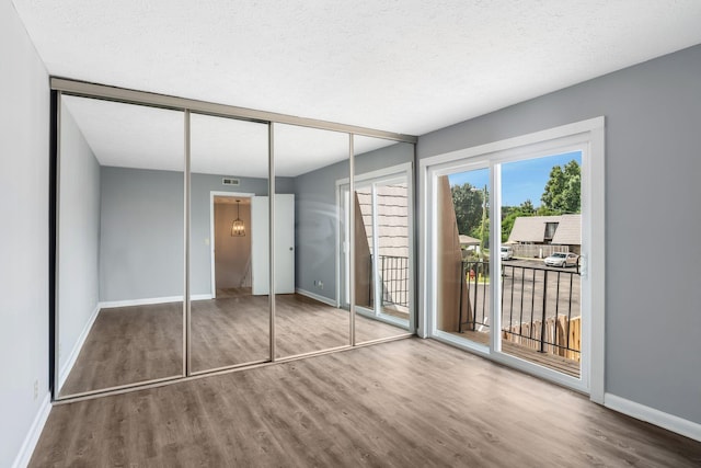 214 Cedarwood Ln Unit 214, Madison, TN 37115 - unfurnished bedroom with access to exterior, wood finished floors, a textured ceiling, and a closet