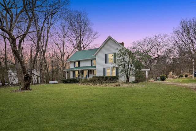 view of front facade with covered porch and a lawn