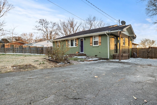 view of front of home featuring crawl space, fence, and brick siding