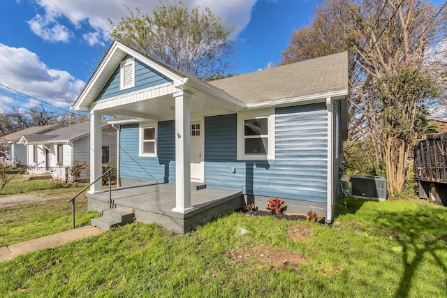 bungalow-style house with central air condition unit, a front lawn, and a porch