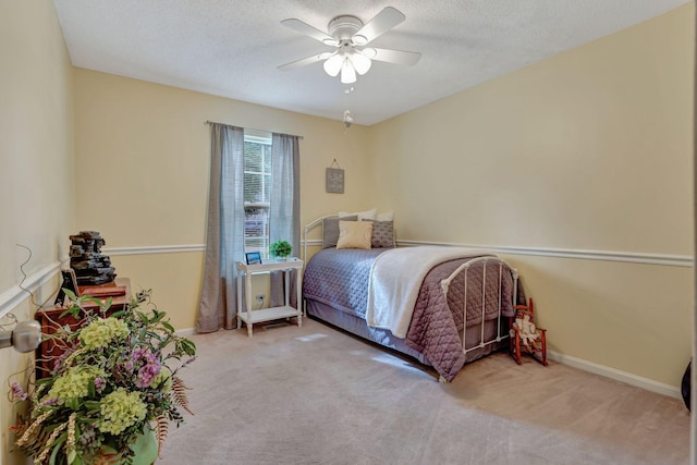 carpeted bedroom with ceiling fan and a textured ceiling