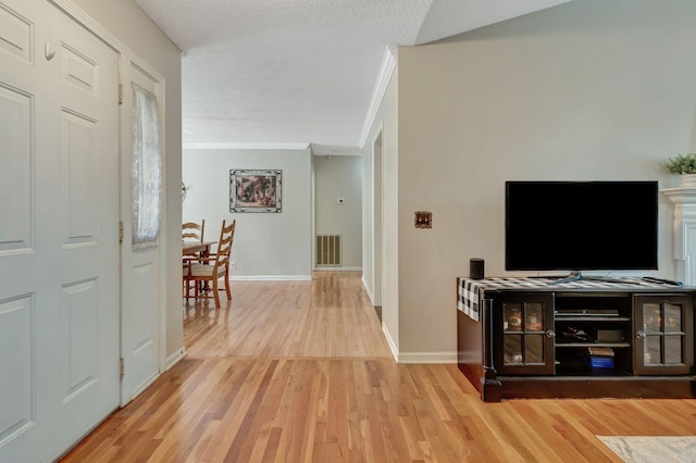 corridor with hardwood / wood-style flooring, crown molding, and a textured ceiling