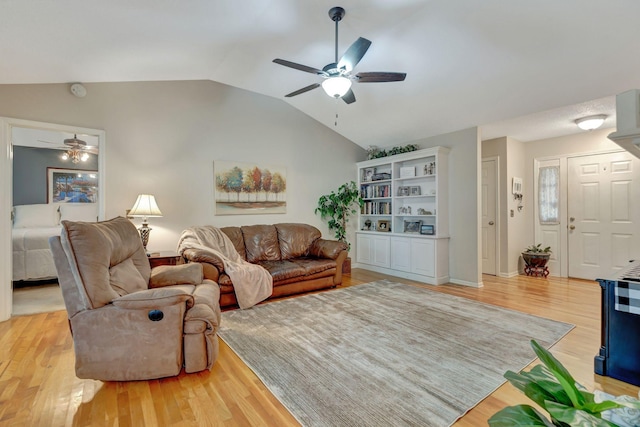 living room featuring vaulted ceiling, ceiling fan, and light hardwood / wood-style flooring