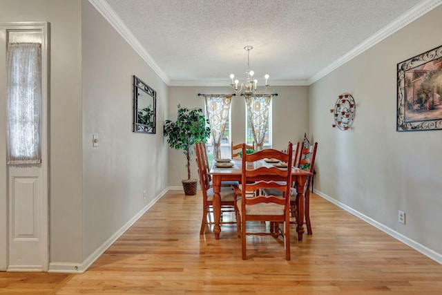 dining space featuring an inviting chandelier, crown molding, a textured ceiling, and light wood-type flooring