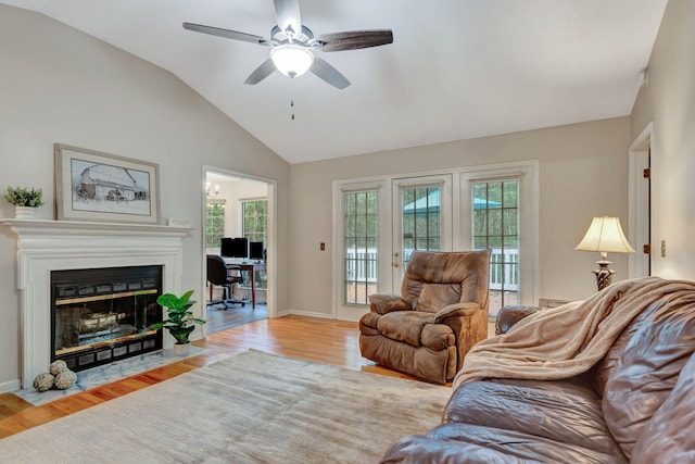 living room with ceiling fan, plenty of natural light, lofted ceiling, and light wood-type flooring