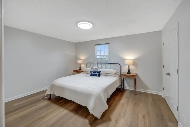 bedroom with light hardwood / wood-style flooring and a textured ceiling