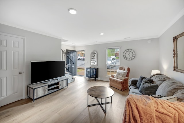 living room with ornamental molding and light wood-type flooring