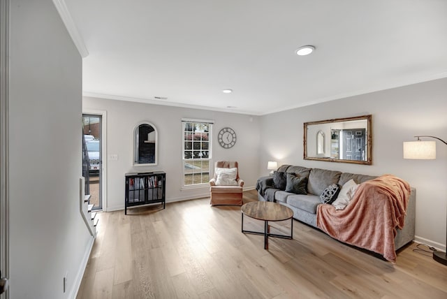 living room with ornamental molding and light hardwood / wood-style floors