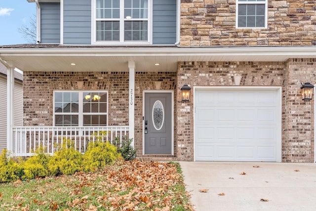 view of exterior entry with a porch and a garage