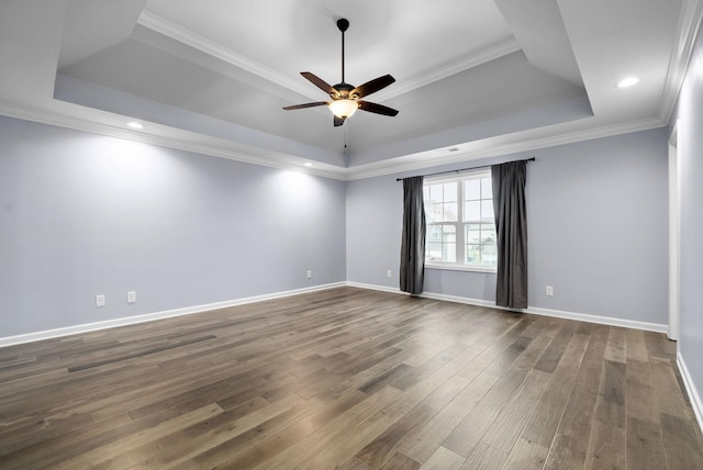 unfurnished room featuring ceiling fan, ornamental molding, dark wood-type flooring, and a raised ceiling