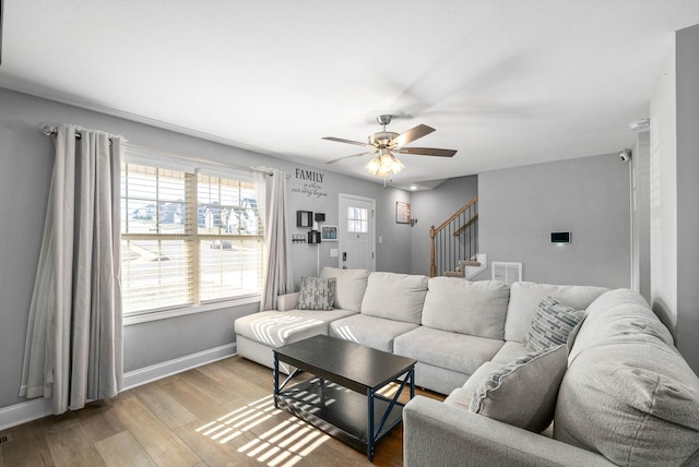 living room with ceiling fan and light hardwood / wood-style flooring