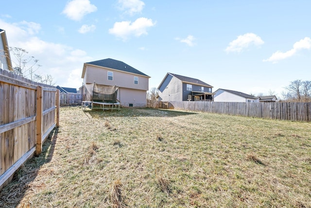 rear view of house with a trampoline and a lawn