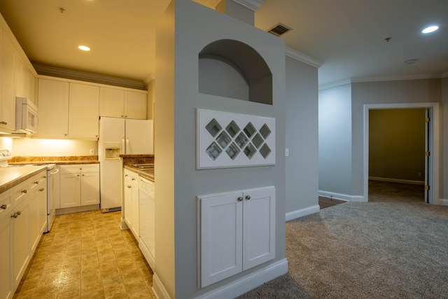 kitchen with ornamental molding, white appliances, white cabinetry, and light carpet