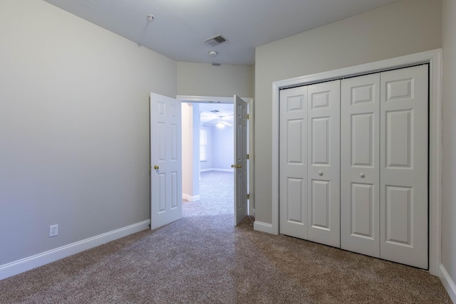 unfurnished bedroom featuring a closet and light colored carpet