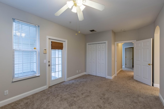 unfurnished bedroom featuring light carpet, ceiling fan, and a closet