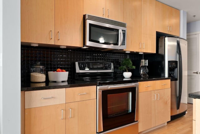 kitchen with appliances with stainless steel finishes, backsplash, light hardwood / wood-style flooring, and light brown cabinets