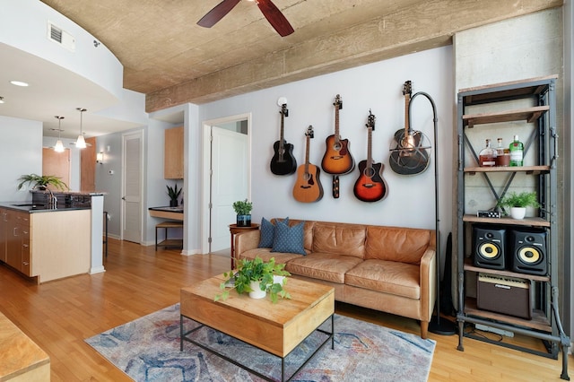 living room featuring ceiling fan, light hardwood / wood-style flooring, and sink