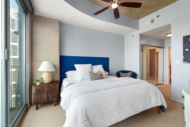 bedroom featuring ceiling fan, access to outside, multiple windows, and light colored carpet