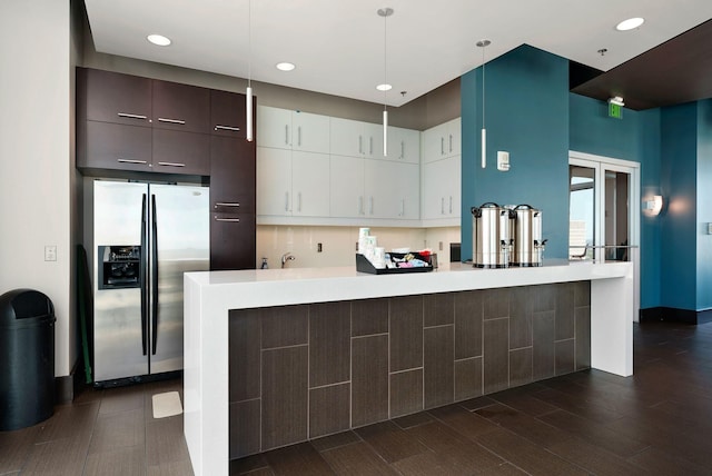 kitchen with stainless steel fridge with ice dispenser, white cabinets, kitchen peninsula, hanging light fixtures, and dark brown cabinets