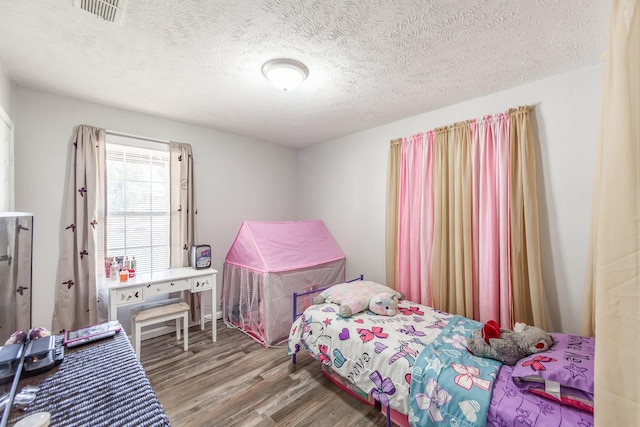 bedroom with wood-type flooring and a textured ceiling